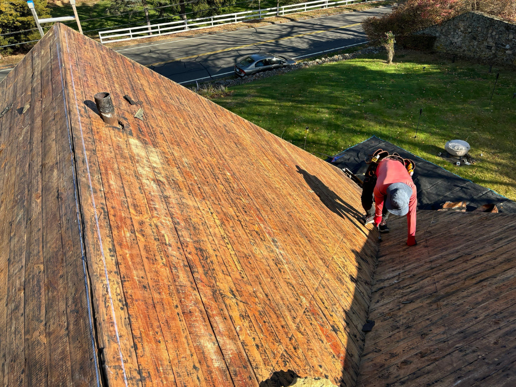 roofer stripping roof to plywood in roof replacement process in danbury ct